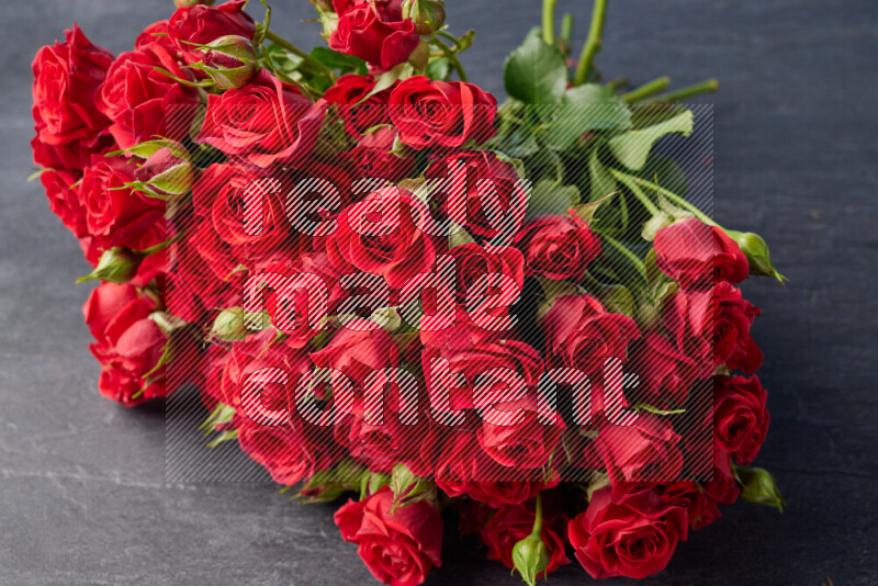 A luxurious bouquet of red roses on black marble background