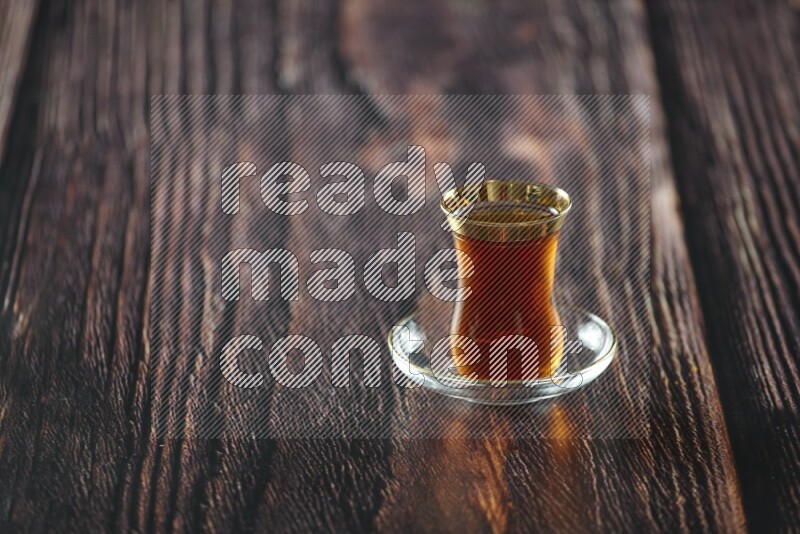 A tea glass cup with dates and coffee on wooden background