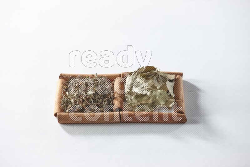 2 squares of cinnamon sticks full of dried basil and bay laurel leaves on white flooring