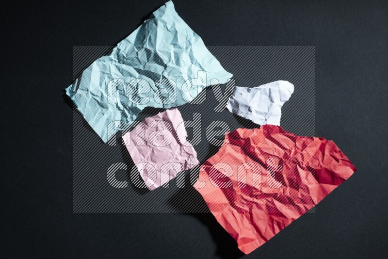 Crumpled multicolored paper on black background