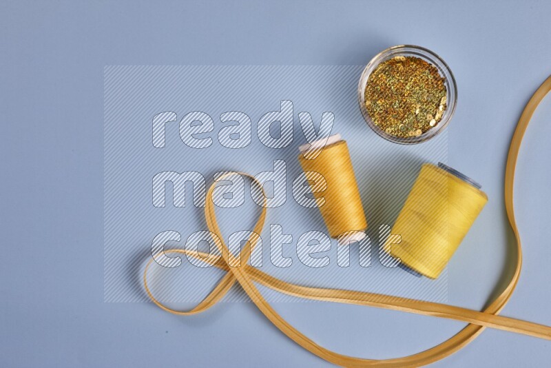 A yellow collection of sewing and tailoring tools arranged on a blue background