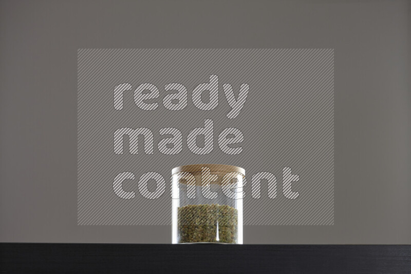 Freekeh in a glass jar on black background