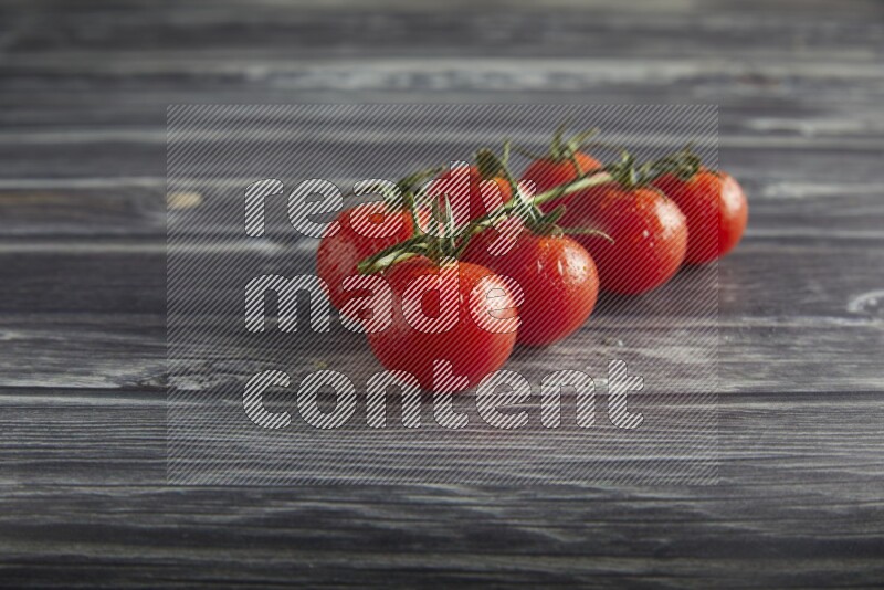 Red cherry tomato vein on a textured grey wooden background 45 degree