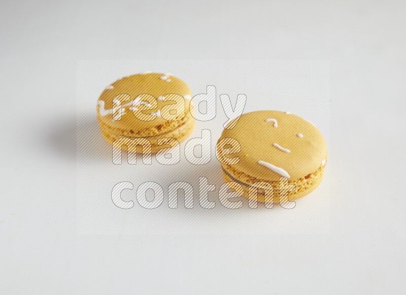45º Shot of two Yellow Piña Colada macarons on white background