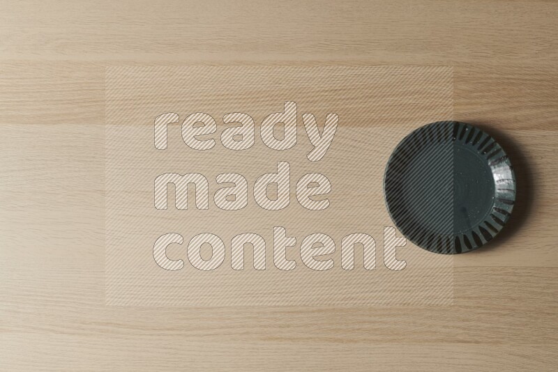 صحن فخاري أخضر داكن على خلفية خشبية فاتحة