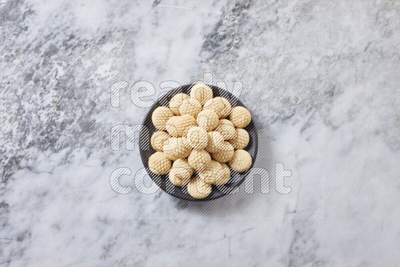 Kahk in black pottery plate on grey marble background