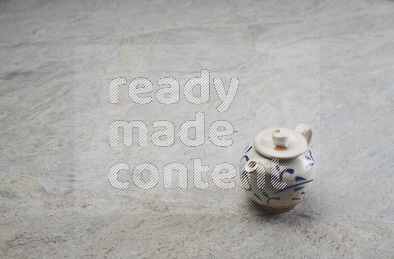 A pottery teapot on grey marble background