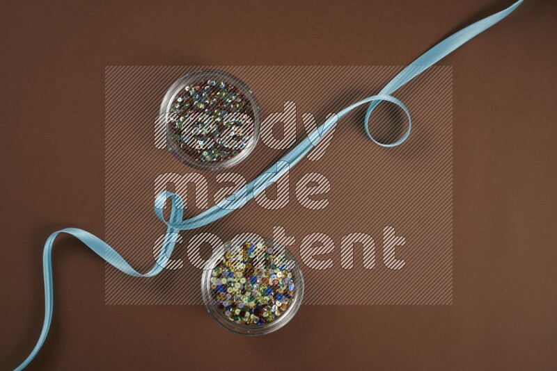 A blue collection of sewing and tailoring tools arranged on a brown background