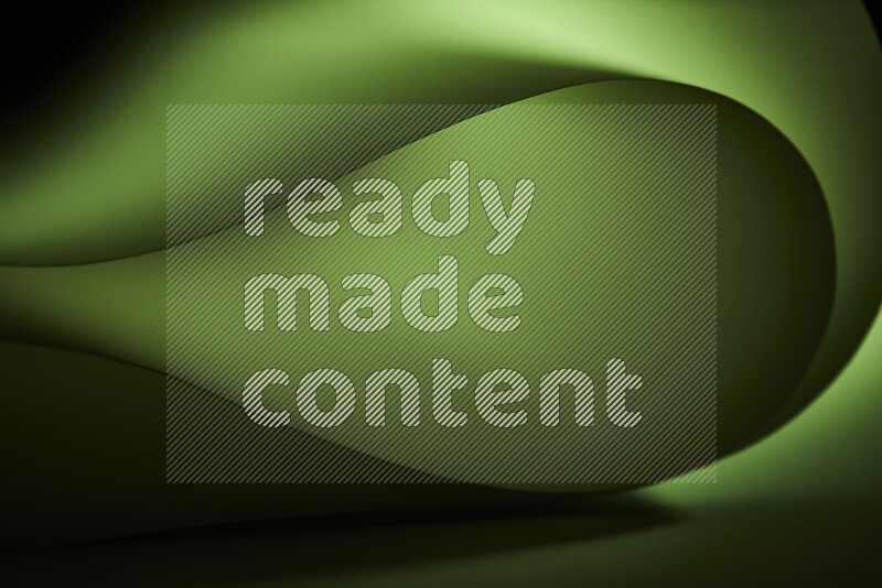 An abstract art piece displaying smooth curves in green gradients created by colored light