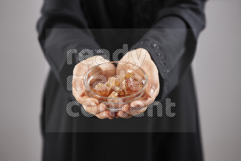 Woman in abaya holding different kinds of spices in different positions
