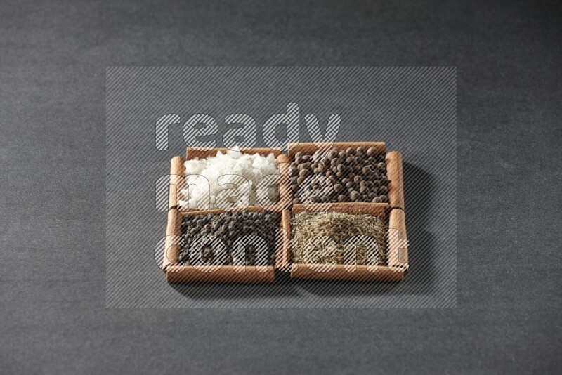 4 squares of cinnamon sticks full of black pepper, cumin, allspice and white salt on black flooring