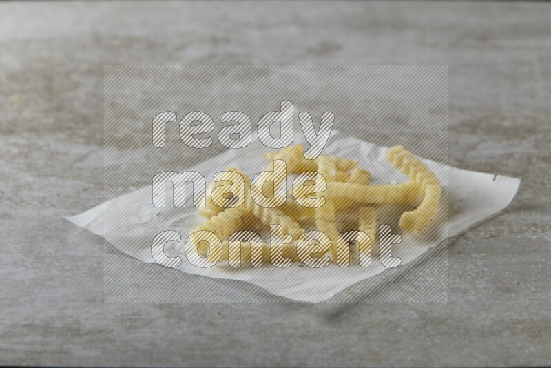 crinkle fries on parchment paper on grey textured counter top