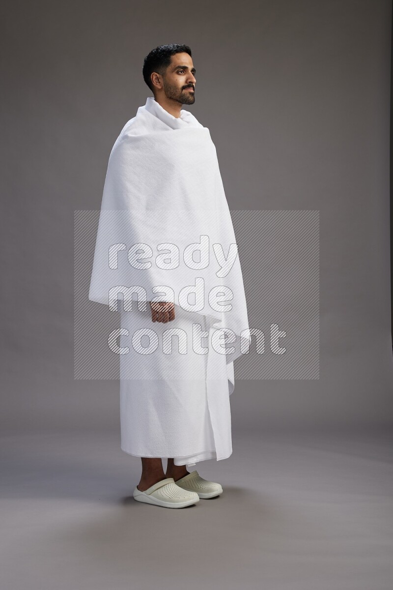 A man wearing Ehram Standing Interacting with the camera on gray background