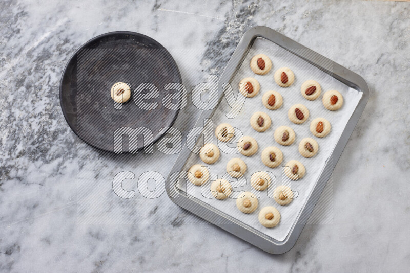 Ghoriba step by step with its ingredient, flour, powdered sugar, ghee and nuts on grey marble background