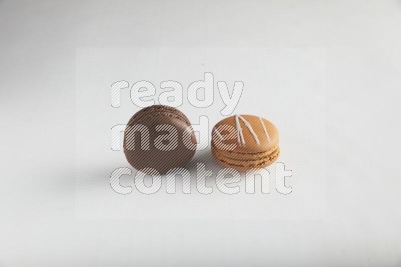 45º Shot of of two assorted Brown Irish Cream, and Brown Dark Chocolate macarons on white background