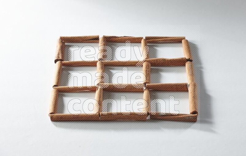 9 empty squares of cinnamon sticks on white flooring
