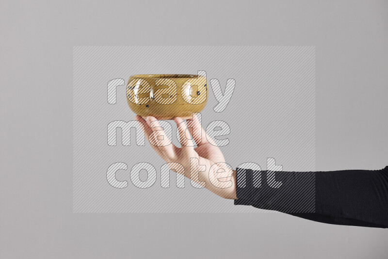 A woman in black abaya holding different pottery essentials in different positions