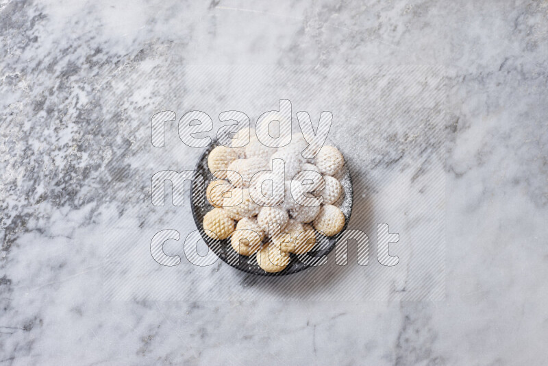 Kahk in black pottery plate on grey marble background