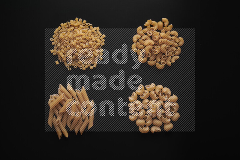 Different pasta types in bunches on black background