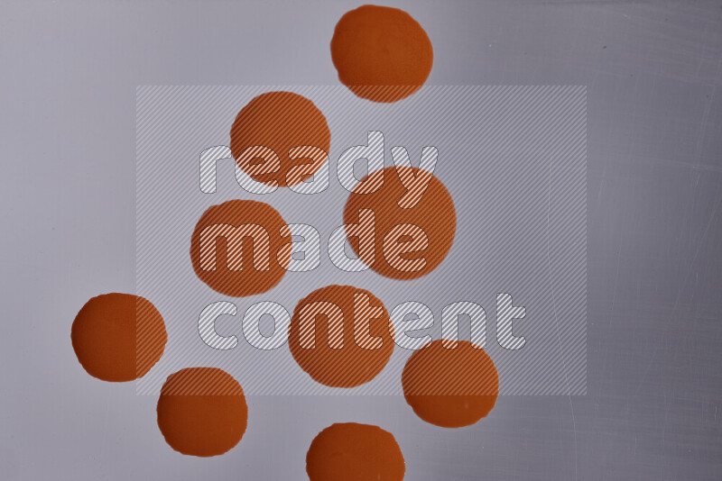 Close-ups of abstract orange paint droplets on the surface