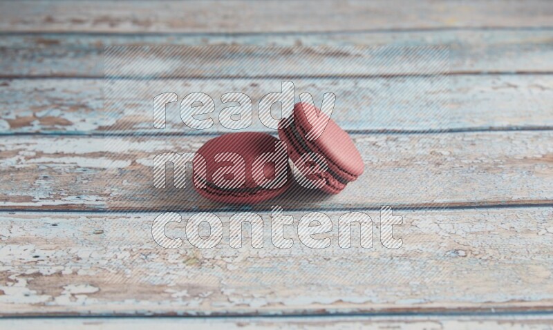 45º Shot of two Red Cherry macarons on light blue wooden background