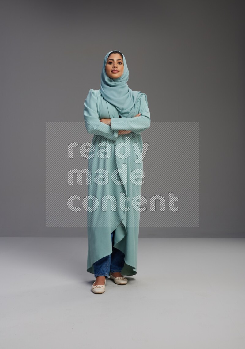 Saudi Woman wearing Abaya standing with crossed arms on Gray background