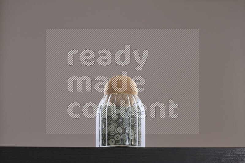 Buttons in a glass jar on black background