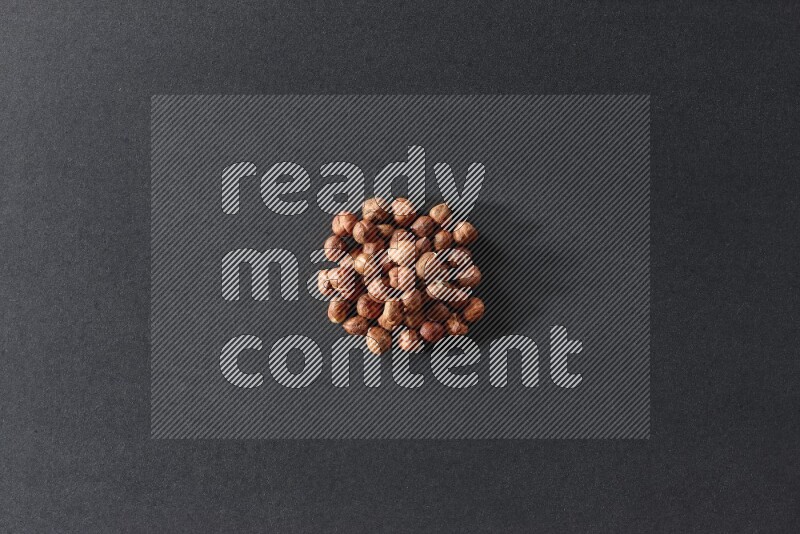 A bunch of peeled hazelnuts on a black background in different angles