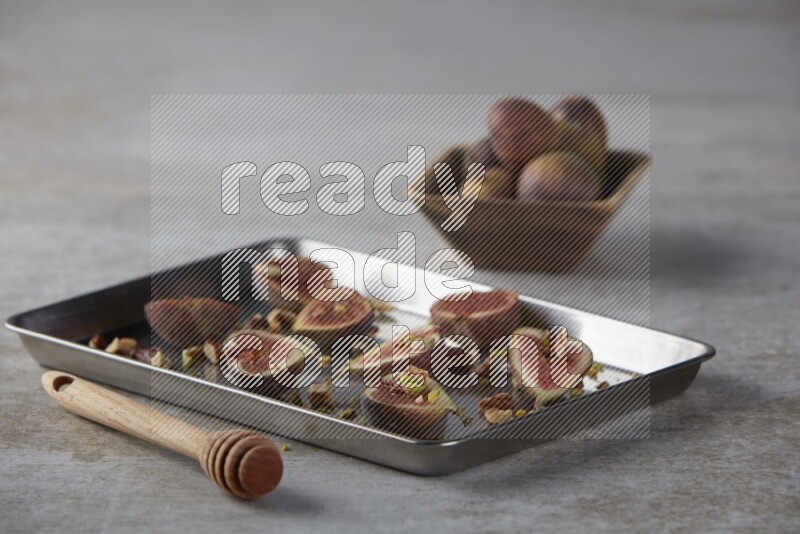 fresh figs on an oven tray on a textured grey background