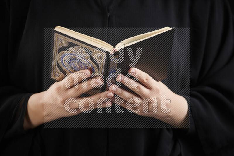 A woman hands holding moshaf in different positions