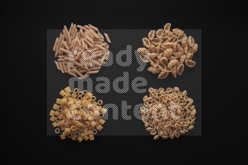 Different pasta types in bunches on black background