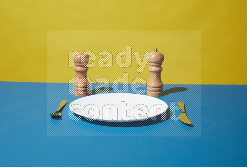 white plate and silverware on yellow and blue background