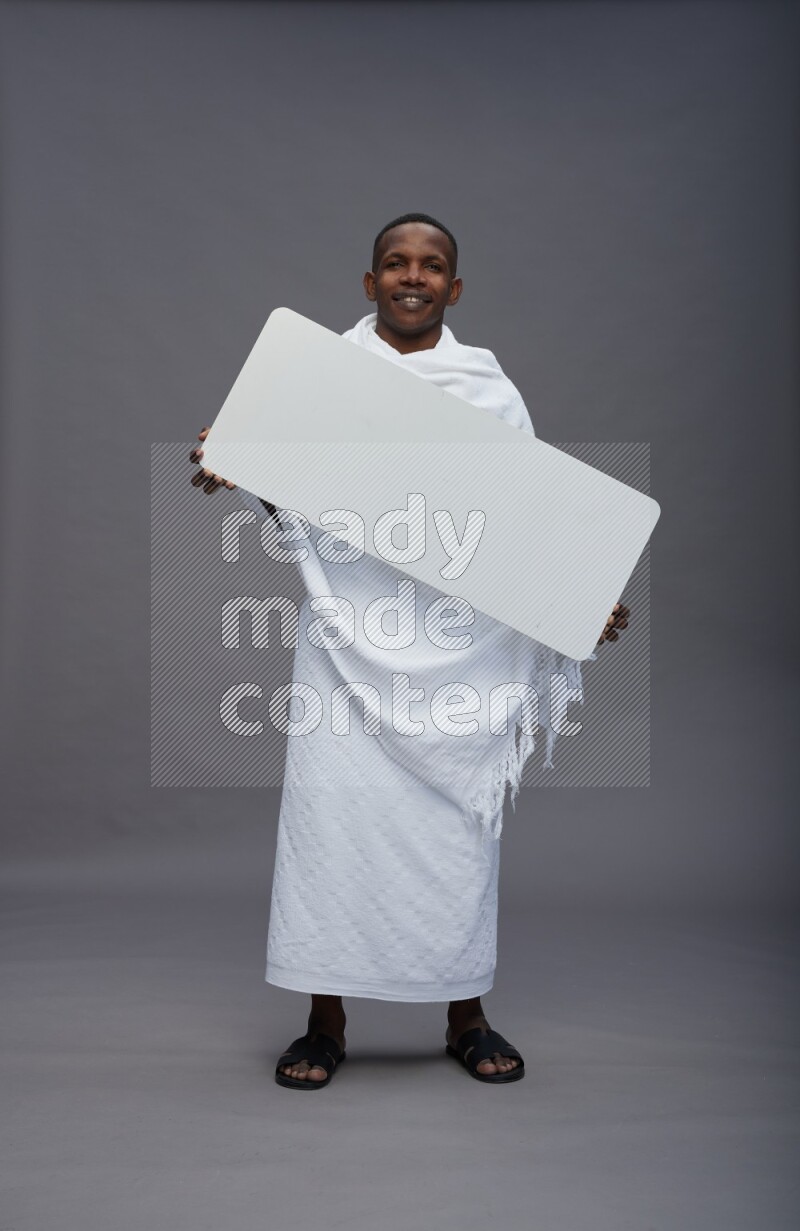 A man wearing Ehram Standing holding board sign on gray background