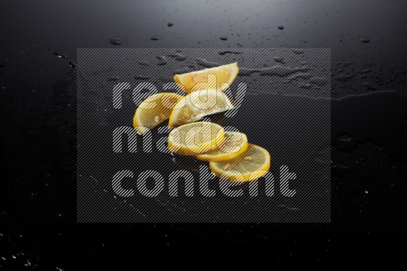 Lemon slices with water drops, and droplets on black background