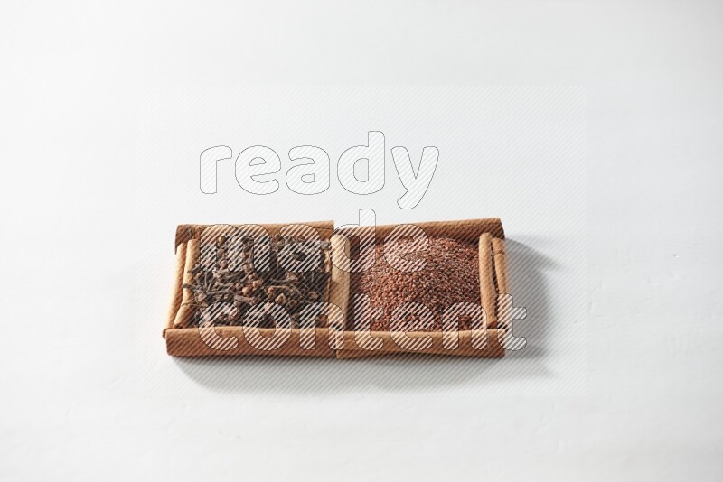 2 squares of cinnamon sticks full of garden cress and cloves on white flooring