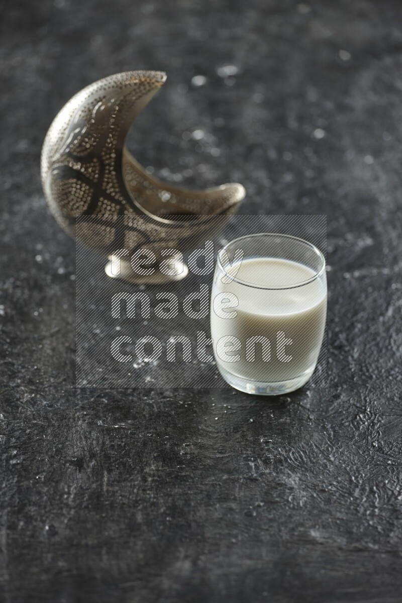 فانوس فضي مع مشروبات مختلفة وتمر ومكسرات وسبحة صلاة وقرآن على خلفية سوداء