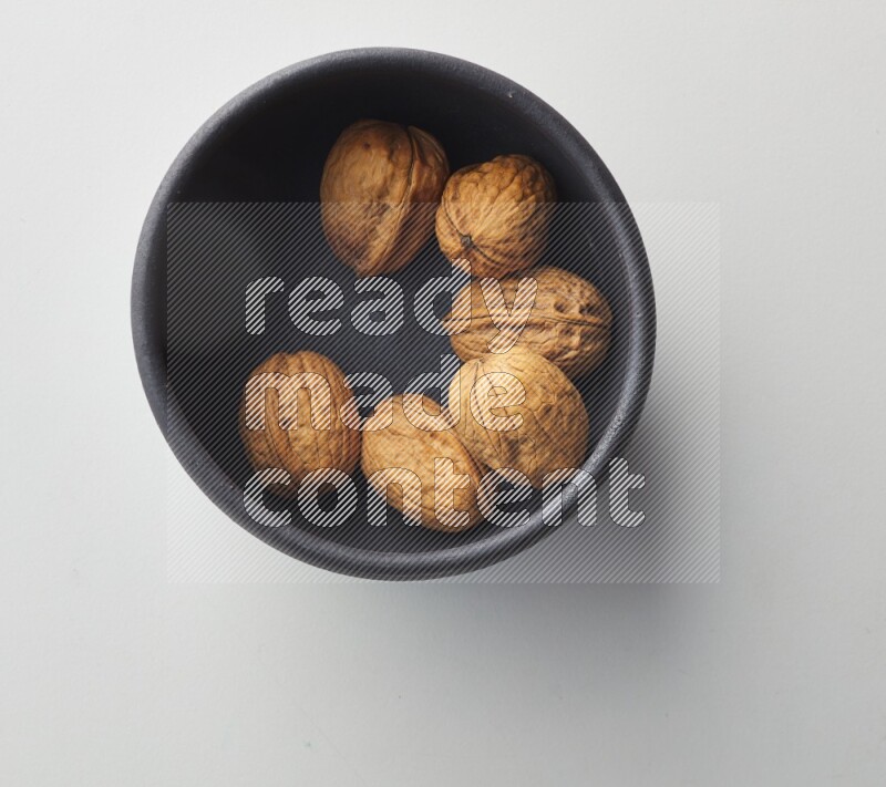 Top-view shot of walnut in a container on white background