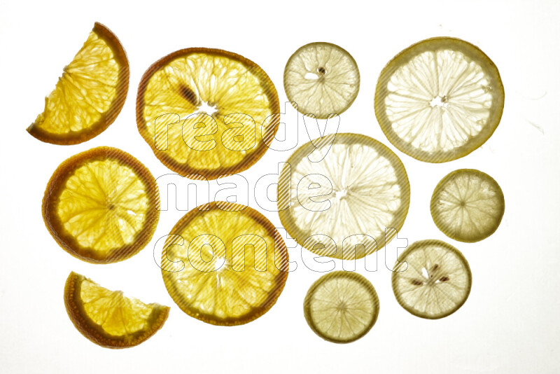 Mixed vegetables and fruits slices on illuminated white background