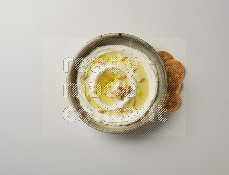 Lebnah garnished with pine nuts in a grey pottery plate on a white background