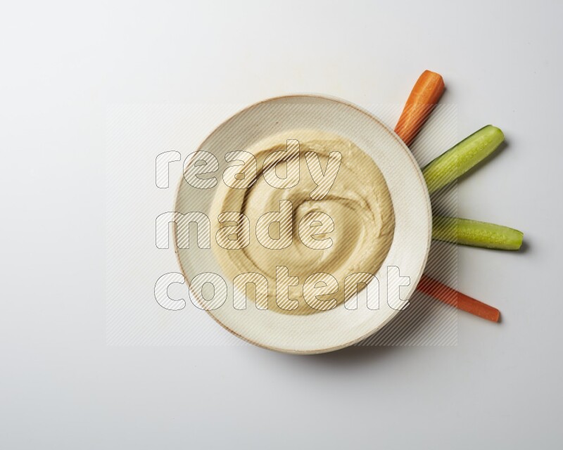 plain Hummus in a pottry plate  on a white background
