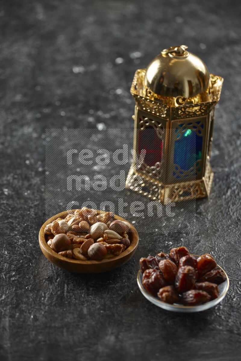 A golden lantern with different drinks, dates, nuts, prayer beads and quran on textured black background