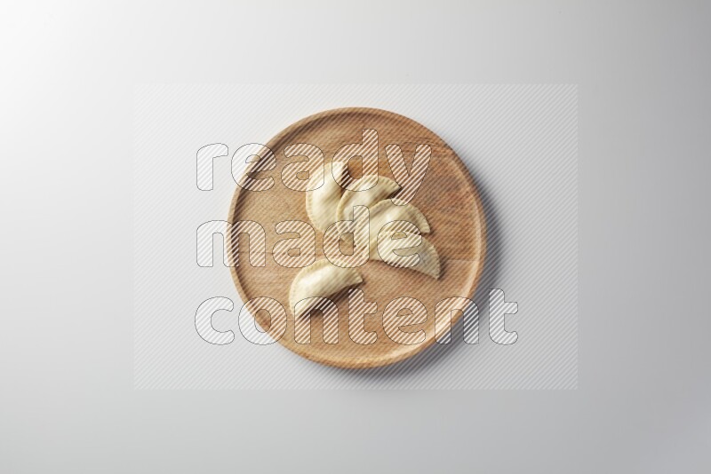 Five Sambosas on a wooden round plate on a white background