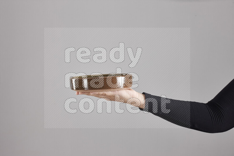 A woman in black abaya holding different pottery essentials in different positions