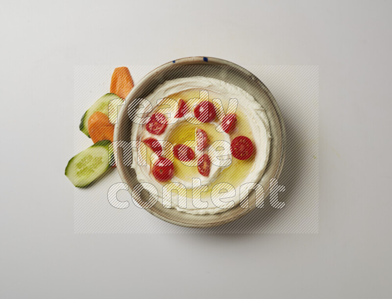 Lebnah garnished with cherry tomato in a grey pottery plate on a white background