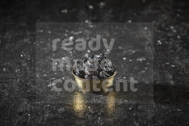 فواكه مجففة في وعاء معدني علي خلفية سوداء