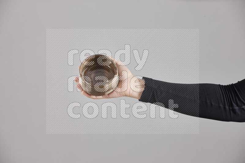 امرأة ترتدي عباءة سوداء تحمل أدوات فخارية مختلفة في أوضاع متعددة