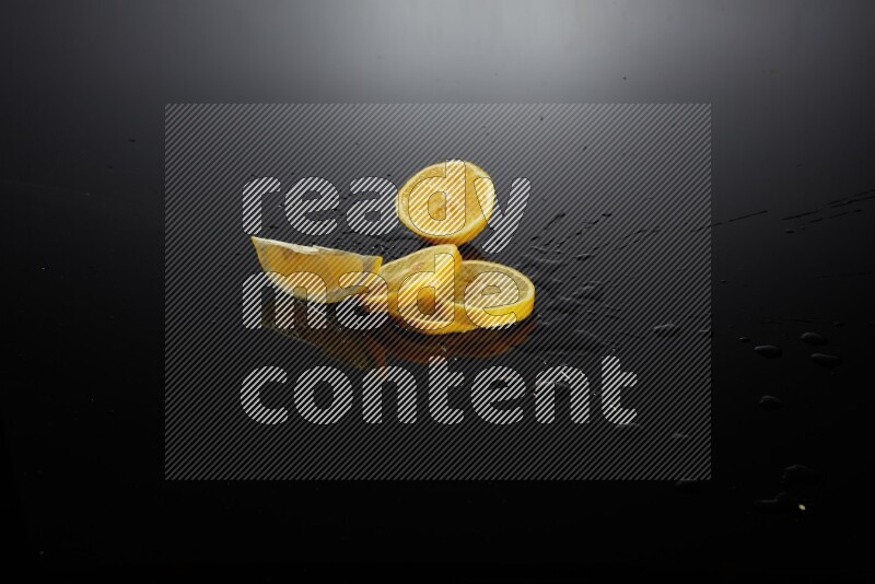 Lemon slices with water drops, and droplets on black background