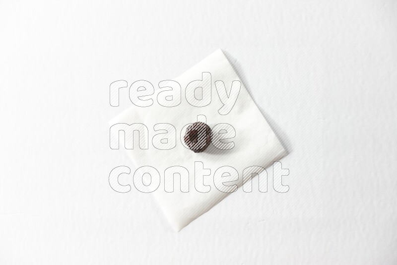 A dried plum on a piece of paper on a white background in different angles