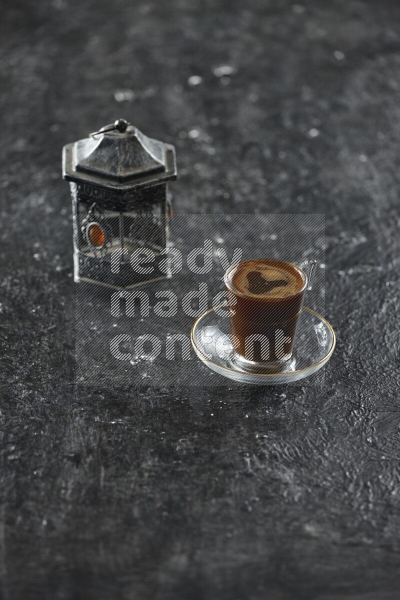 A silver lantern with different drinks, dates, nuts, prayer beads and quran on textured black background