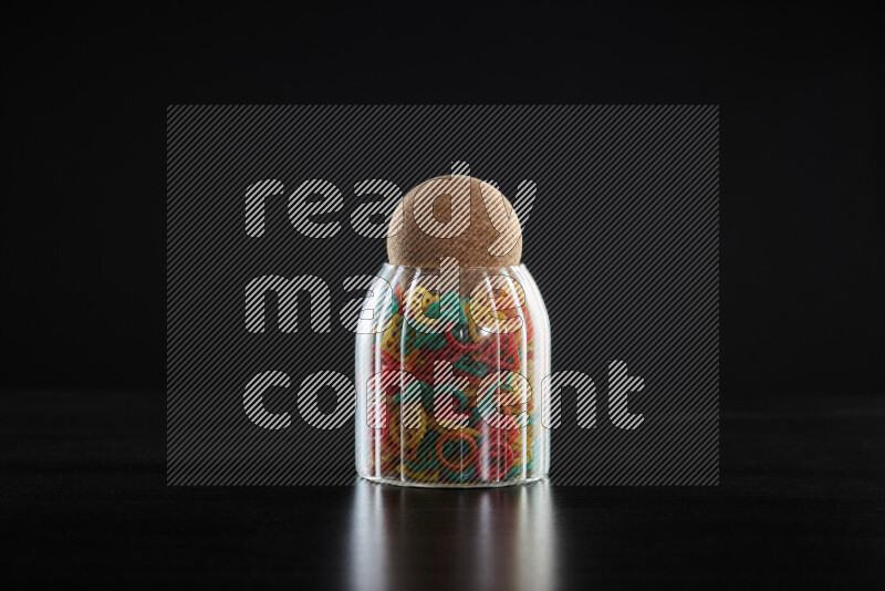 Snacks in a glass jar on black background